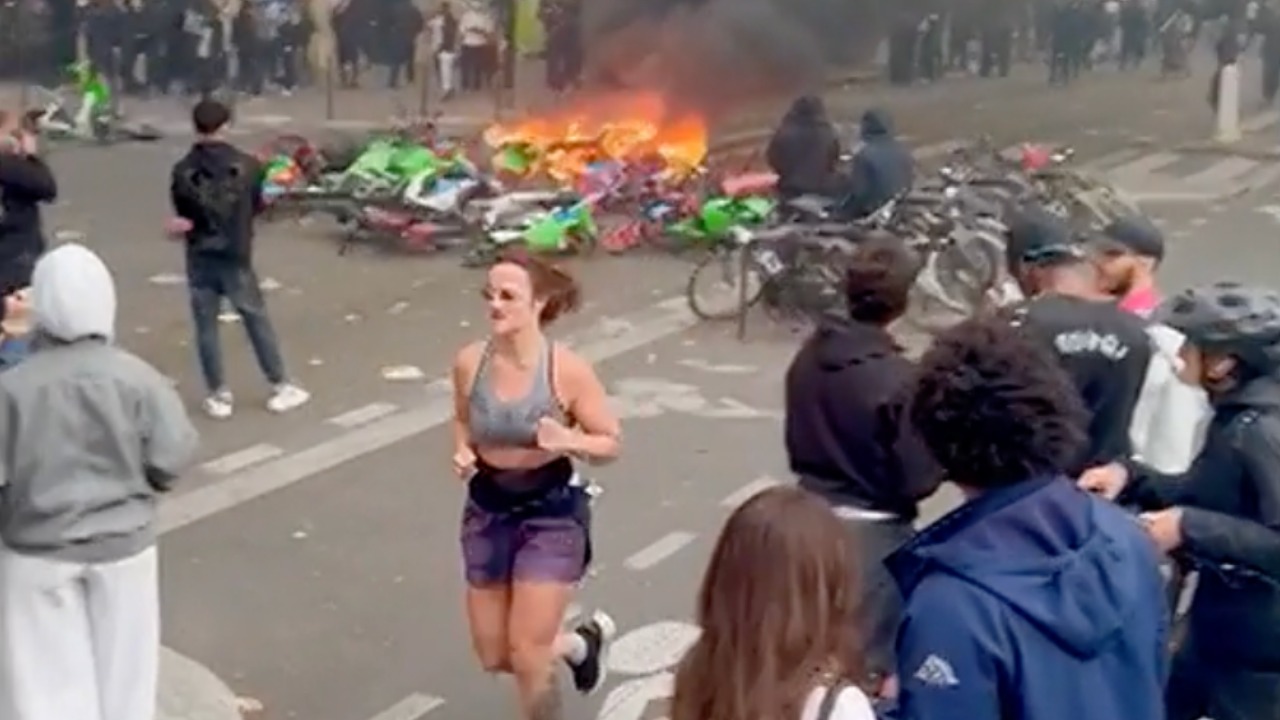 Unfazed jogger casually runs through chaotic Paris protests